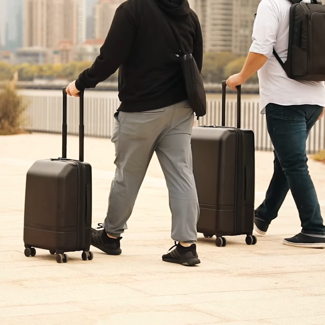 Men traveling with Nomatic Carry-on Classic Luggage